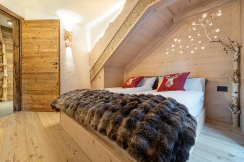 a bedroom with two beds in a wooden room at Mas del Mezdì - mountain chalet Val di Rabbi in Rabbi