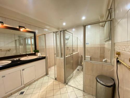 a bathroom with a shower and a sink and a toilet at Stone House Quezon City in Manila