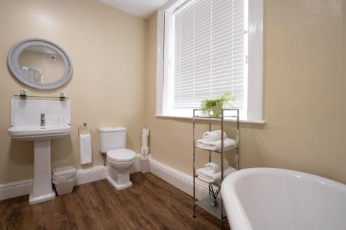 a bathroom with a toilet and a sink and a mirror at Hassop Station rooms on the Monsal Trail in Bakewell
