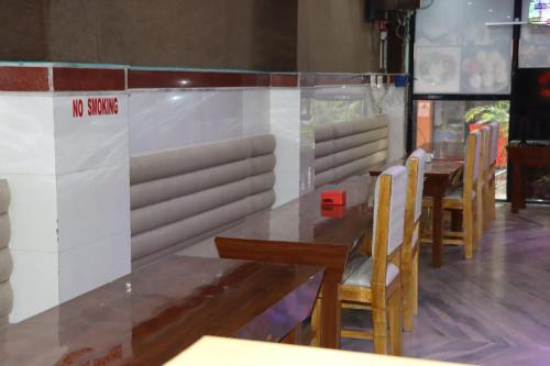 Holiday Inn في Kakarvitta: غرفة طعام بها طاولات وكراسي و لافتة ممنوع التدخين