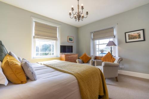 a bedroom with a large bed and a chandelier at Hassop Station rooms on the Monsal Trail in Bakewell
