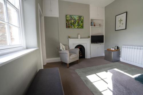a living room with a fireplace and a chair at Hassop Station rooms on the Monsal Trail in Bakewell