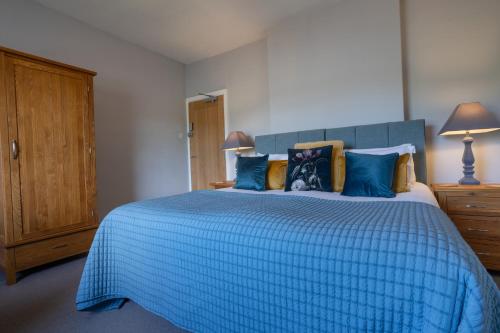 a bedroom with a blue bed with a blue comforter at Hassop Station rooms on the Monsal Trail in Bakewell