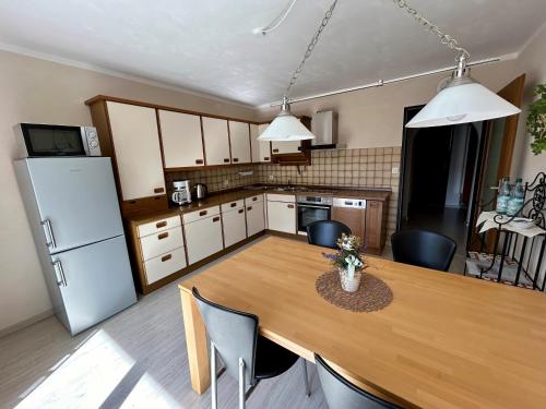 a kitchen with a wooden table and a refrigerator at Ferienwohnung Kastl in Kastl