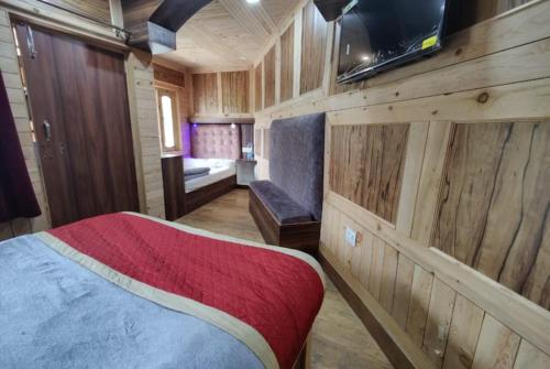 1 dormitorio con 1 cama, TV y sofá en Hotel Payal Mall Road Lake View Nainital - Prime Location - Spacious and Hygiene Room, en Nainital