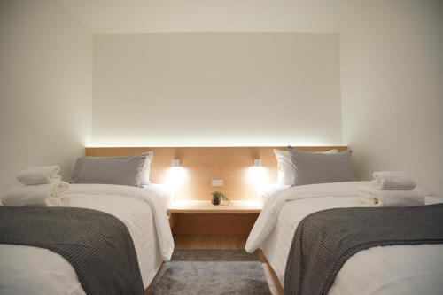 a room with two beds and a desk between them at E11 Hotel - BTS Punnawithi in Amphoe Phra Khanong