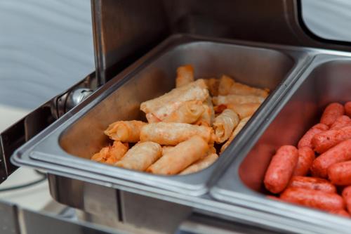 a tray of food with hot dogs and other foods at Ada Hotel in Tashkent