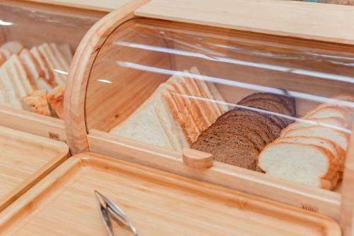 a wooden cabinet with a container with bread in it at Ada Hotel in Tashkent