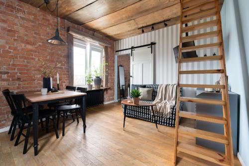 a dining room and living room with a brick wall at Flatbook - In the Heart of Old Town Apartments Sw Ducha in Gdańsk