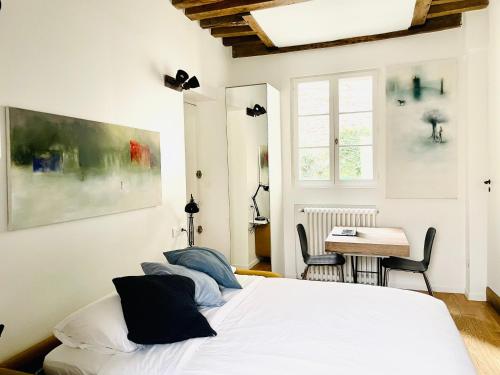 una camera con un letto bianco e un tavolo di Vieux Marly-le-Roi - Studio bien equipé - Matelas haut qualité a Marly-le-Roi