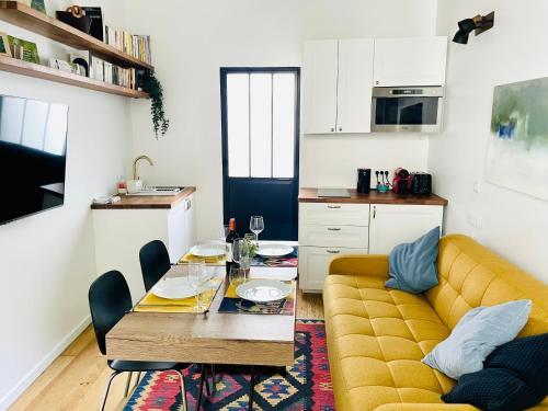 un salon avec un canapé jaune et une table dans l'établissement Vieux Marly-le-Roi - Studio bien equipé - Matelas haut qualité, à Marly-le-Roi