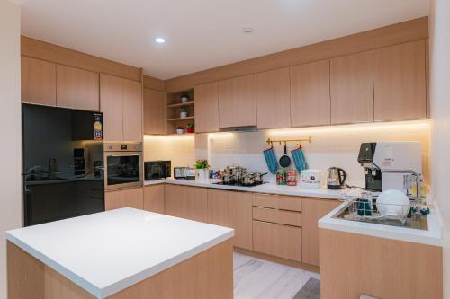 a large kitchen with wooden cabinets and white counter tops at MODERN - CITY CENTER, Phrom Phong BTS, Em District, Terminal 21, MAX 14 People in Bangkok
