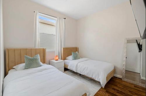 1 Schlafzimmer mit 2 Betten und einem Fenster in der Unterkunft Stylish Apt in Jersey City 20 min to NYC in Union City