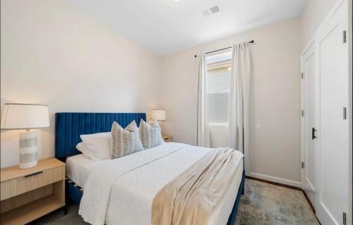 a white bedroom with a bed and a window at Stylish Apt in Jersey City 20 min to NYC in Union City