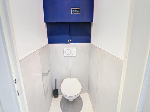 Elle comprend une petite salle de bains pourvue de toilettes et de placards bleus. dans l'établissement 1 bedroom Velasquez, 5 mins from Croisette 244 Cannes Riviera, à Cannes