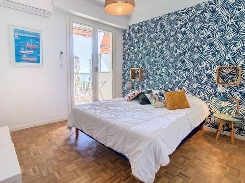 une chambre avec un lit avec un mur bleu et blanc dans l'établissement 1 bedroom Velasquez, 5 mins from Croisette 244 Cannes Riviera, à Cannes