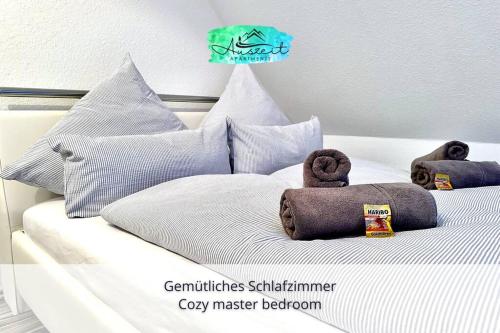 a white bed with stuffed animals on top of it at Auszeit Apartment SUNNY - luxuriöse Maisonette-Wohnung mit tollem Alpenpanorama - 2 sonnige Dachterrassen, schnelles WLAN, kostenloser Tiefgaragenstellplatz, für bis zu 4 Personen in Friedrichshafen