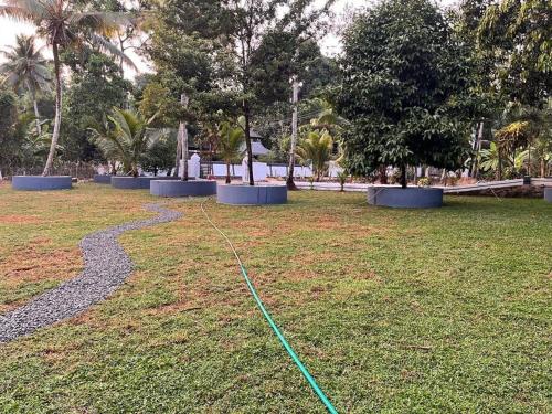 a green hose on the grass in a park at Puthukkeril Heritage Home in Talavadi