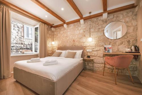 a bedroom with a large bed and a mirror at Mascheroni Luxury Rooms in Dubrovnik