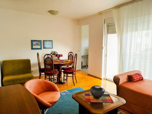 ein Wohnzimmer mit einem Tisch und Stühlen in der Unterkunft Apartments Dubravka Budva in Budva