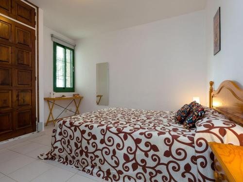 um quarto com uma cama com um edredão preto e branco em Apartamento Llançà, 2 dormitorios, 5 personas - ES-228-41 em Llançà