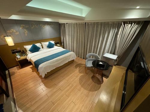 a bedroom with a bed and a table and a chair at Orange Tree International Hotel Zhujiang New Town Huacheng Sqaure Branch - Free Shuttle Bus to Canton Fair Complex During Canton Fair Period in Guangzhou