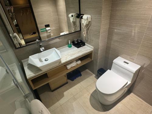 a bathroom with a white toilet and a sink at Orange Tree International Hotel Zhujiang New Town Huacheng Sqaure Branch - Free Shuttle Bus to Canton Fair Complex During Canton Fair Period in Guangzhou