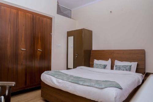 - une chambre avec un grand lit et une armoire en bois dans l'établissement Bobby’s B&B, à Lucknow