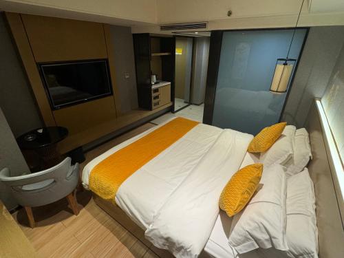 a bedroom with a large white bed with yellow pillows at Orange Tree International Hotel Zhujiang New Town Huacheng Sqaure Branch - Free Shuttle Bus to Canton Fair Complex During Canton Fair Period in Guangzhou