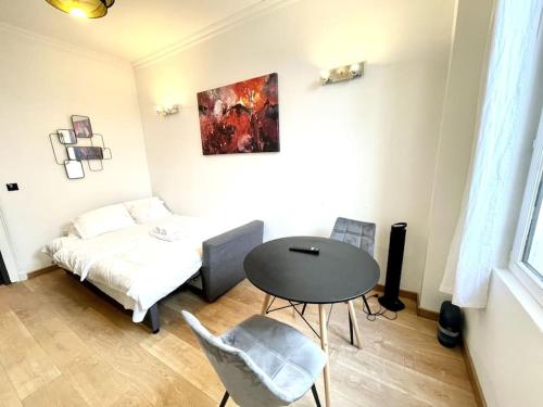 une chambre avec un lit, une table et des chaises dans l'établissement Bercy Arena 2, à Paris