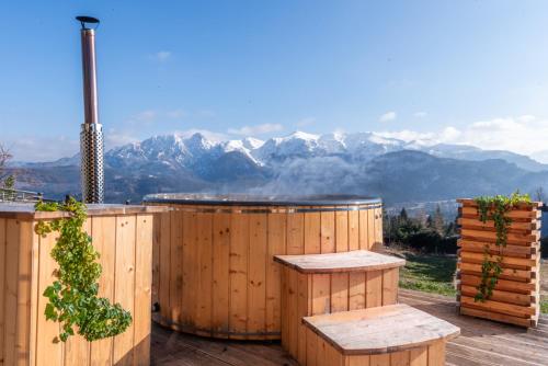 a hot tub on a deck with mountains in the background at City Lights Zakopane in Kościelisko