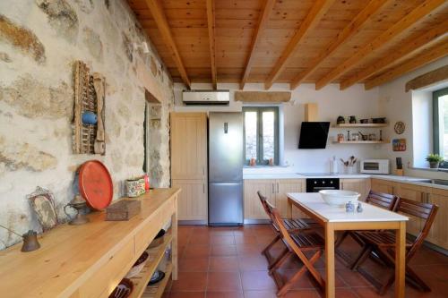 a kitchen with a table and a refrigerator at Dolly's Dream House in Patmos