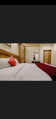 um quarto com 2 camas brancas com almofadas vermelhas em Hotel Green Park em Mumbai