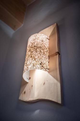 a light hanging on a wall in a room at Mas del Mezdì - mountain chalet Val di Rabbi in Rabbi