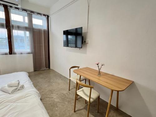 a small room with a table and a bed at Sabay Home in Bangkok