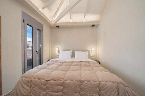 a large bed in a white room with a window at Ariadne's House in Sami