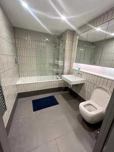 a bathroom with a toilet and a sink and a tub at 1 bedroom Apartment Tottenham Hale in London