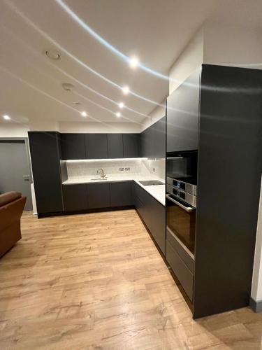 a kitchen with black cabinets and a counter top at 1 bedroom Apartment Tottenham Hale in London
