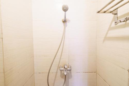 a shower with a shower head on a wall at OYO 93834 The Jarrdin Apartment By Yedi Property in Bandung