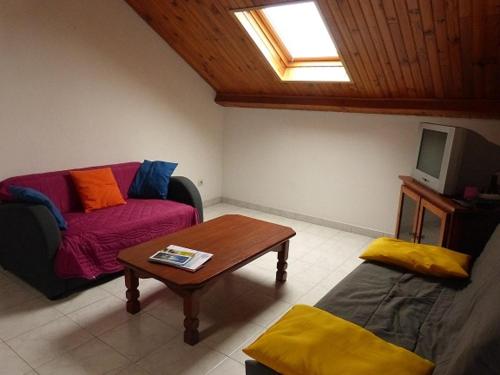 un salon avec un canapé et une table dans l'établissement APPARTEMENT AVEC TERRASSE ET BARBECUE, à Granville