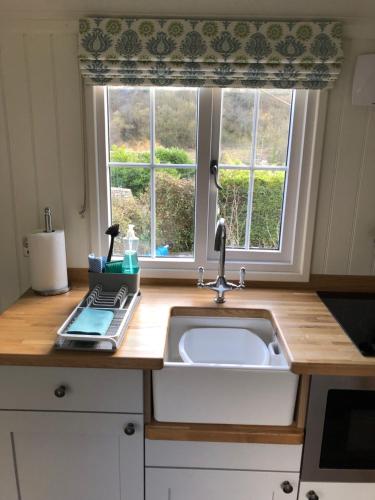 a kitchen counter with a sink and a window at Green Valley, Cotswold stay with hamper in Cheltenham