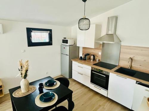 une cuisine avec une table et une cuisinière four supérieur dans l'établissement Studio au cœur des Alberes, à Laroque-des-Albères