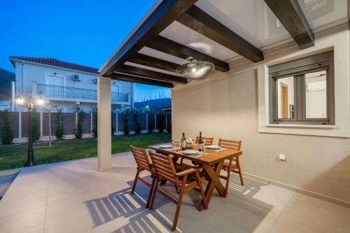 a patio with a wooden table and chairs at Ariadne's House in Sami