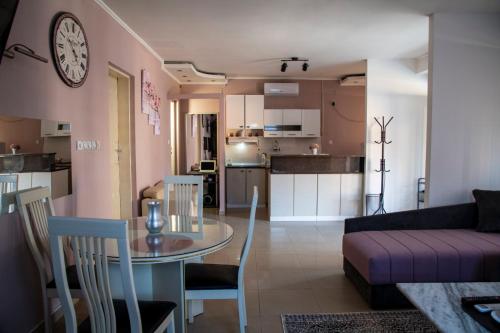een woonkamer en een keuken met een tafel en een bank bij Apartman Lara in Kuršumlija