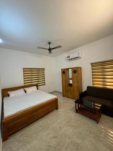 1 dormitorio con 1 cama y 1 sofá en Oasia homestay, en Chāvasseri