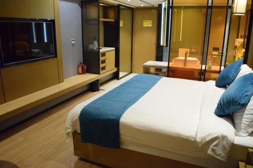 a bedroom with a large bed and a television at Orange Tree International Hotel Zhujiang New Town Huacheng Sqaure Branch - Free Shuttle Bus to Canton Fair Complex During Canton Fair Period in Guangzhou