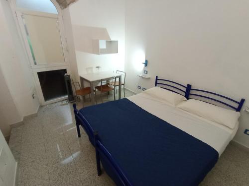 Un dormitorio con una cama azul y blanca y una mesa en Casa vacanze Riomaggiore, en Riomaggiore