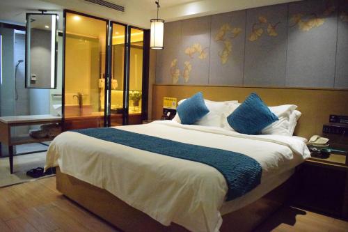 a bedroom with a large bed and a bathroom at Orange Tree International Hotel Zhujiang New Town Huacheng Sqaure Branch - Free Shuttle Bus to Canton Fair Complex During Canton Fair Period in Guangzhou