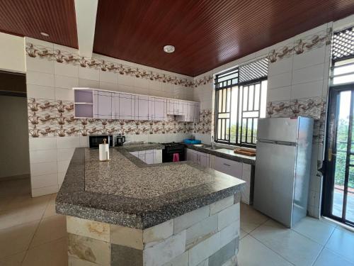a kitchen with a counter top and a refrigerator at BELINDA APPARTEMENT in Rubavu