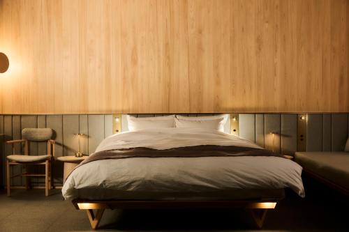 富士河口湖的住宿－GEN.（富士クラシックホテル），一间卧室配有一张大床和一把椅子